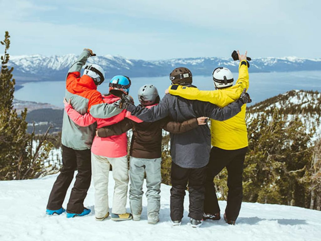 Friends standing looking over Lake Tahoe at the edge of Heavenly Ski Mountain